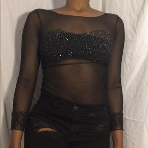 Sheer black top with sequins on chest and wrist.